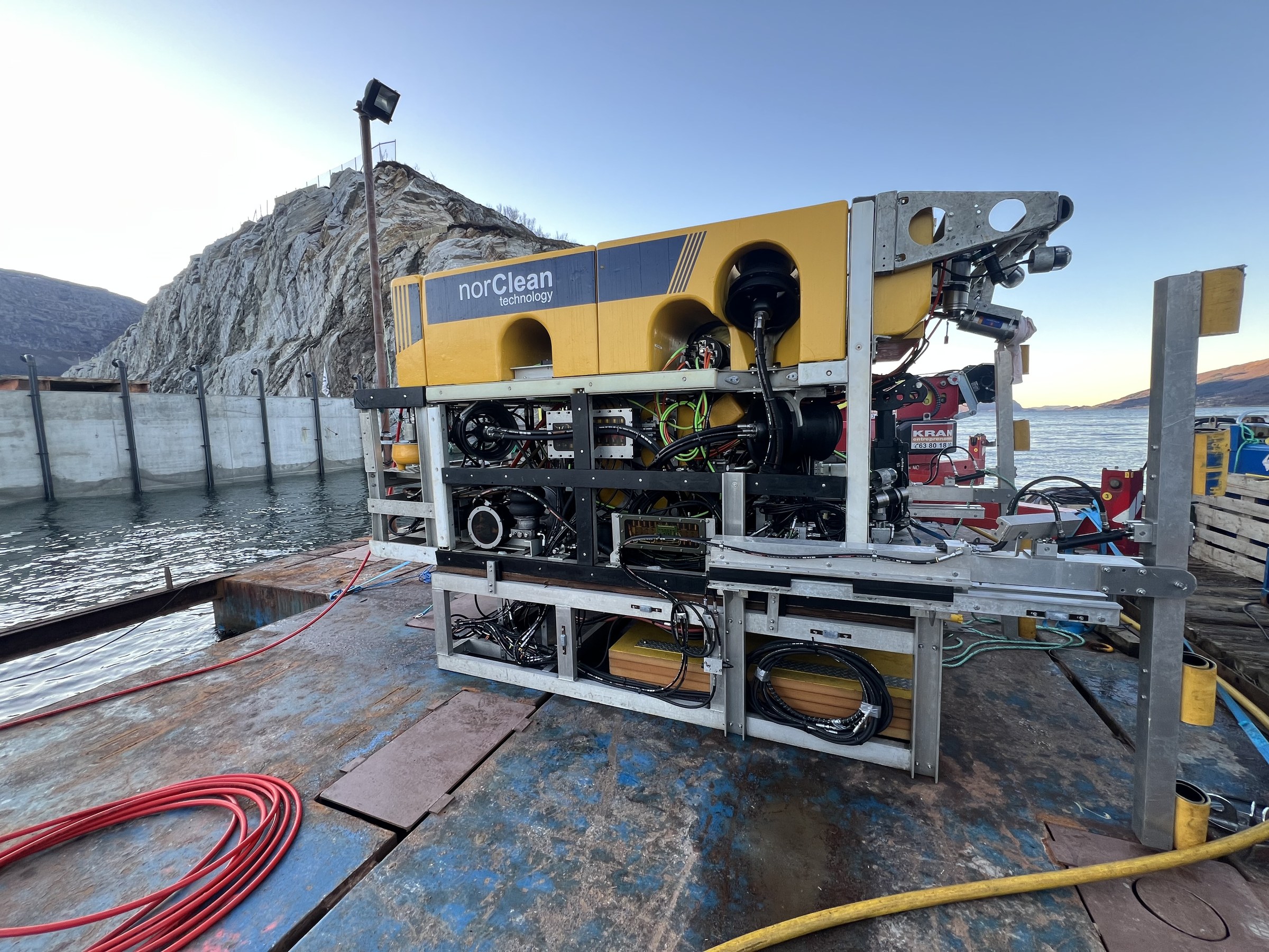 Work-class ROV with custom drilling tooling operating against a subsea rock face
